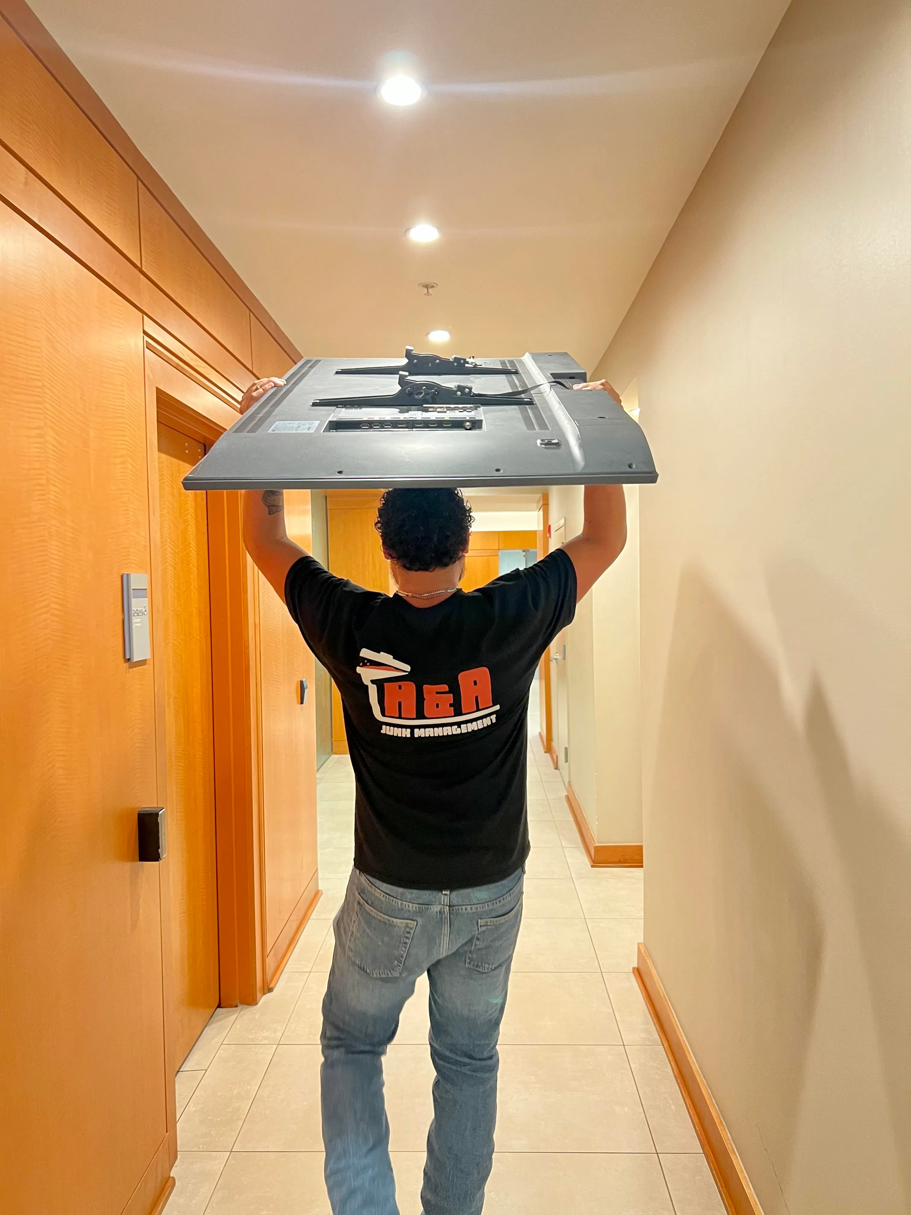 A&A Junk Management crew member carrying items for removal
